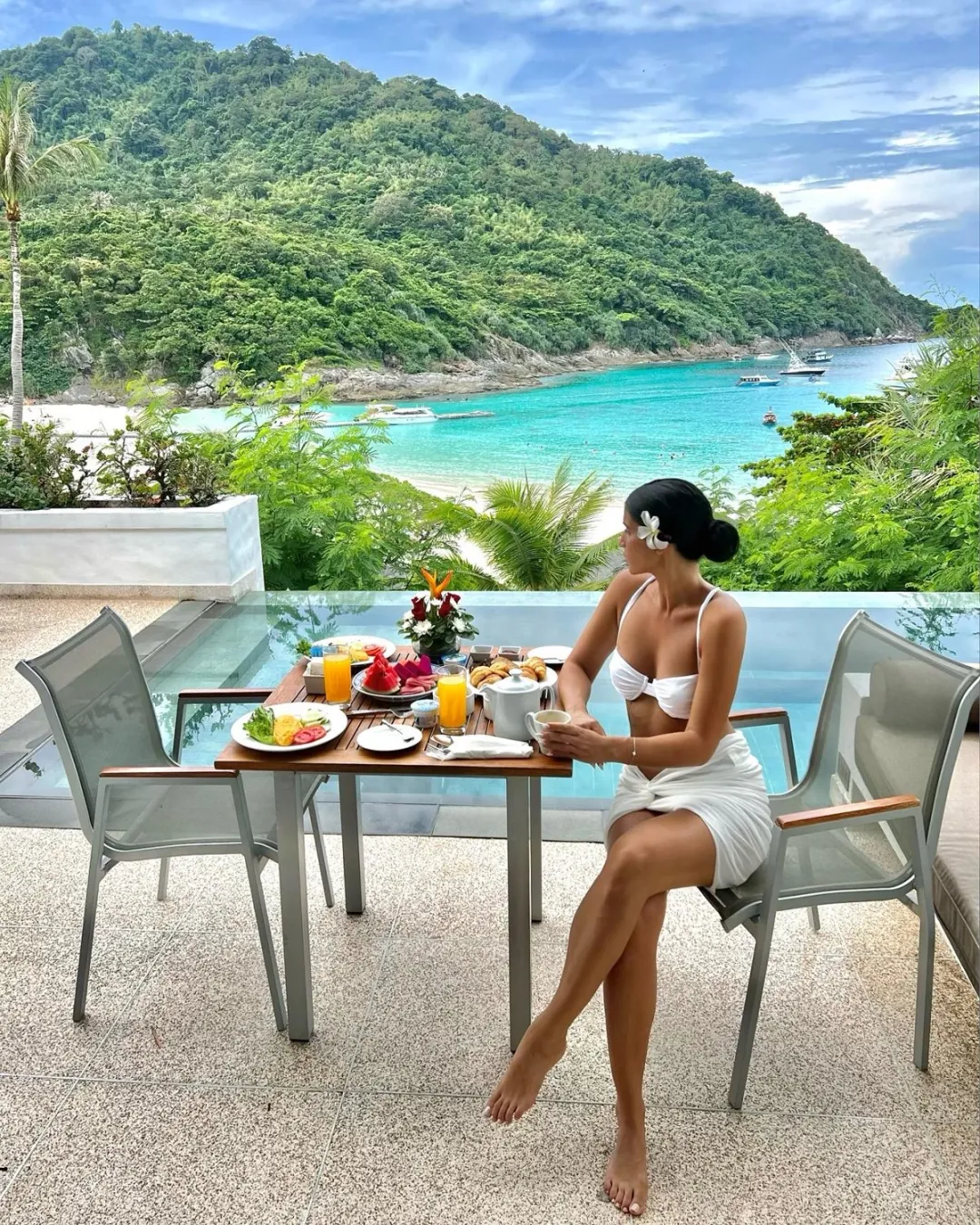 Shani at breakfast on a terrace overlooking a tropical bay