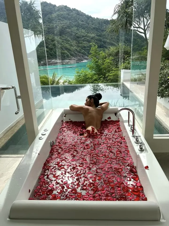 Shani in a rose-petal bath overlooking a green tropical bay