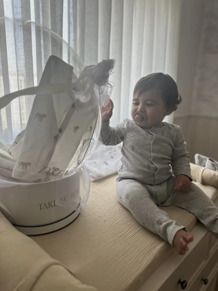 Baby opening a Take Me Home gift box