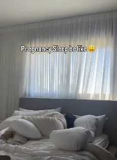 Reel about pregnancy sleep: a bed piled with pillows
